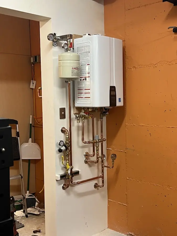Plumbing technician inspecting water heater connections in Ozark